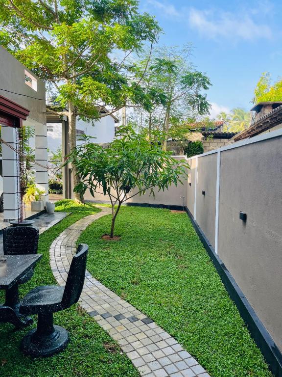 a garden with a bench and a grass yard at Letharo Residancies in Dodanduwa