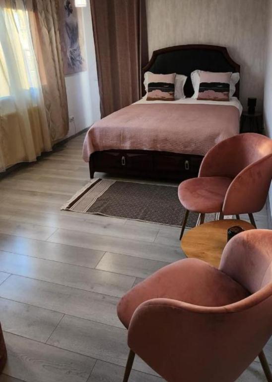a bedroom with a bed and two chairs at Morii Lake Studio in Bucharest