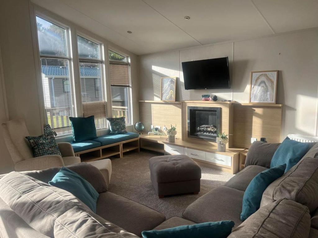 a living room with a couch and a tv at Pinehurst, 65 Golf View Lodge in Jedburgh
