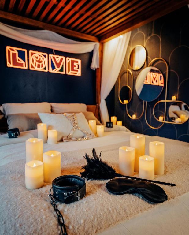 a room with a bed with candles on it at L'Eure de Luxure Loveroom Suite in Normandy in Évreux