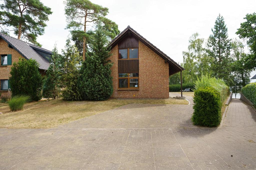 a brick house with a large window on a driveway at Haus 17 in Röbel