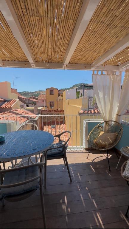 a patio with a table and chairs on a balcony at DOMMO ASULETTA in Bosa