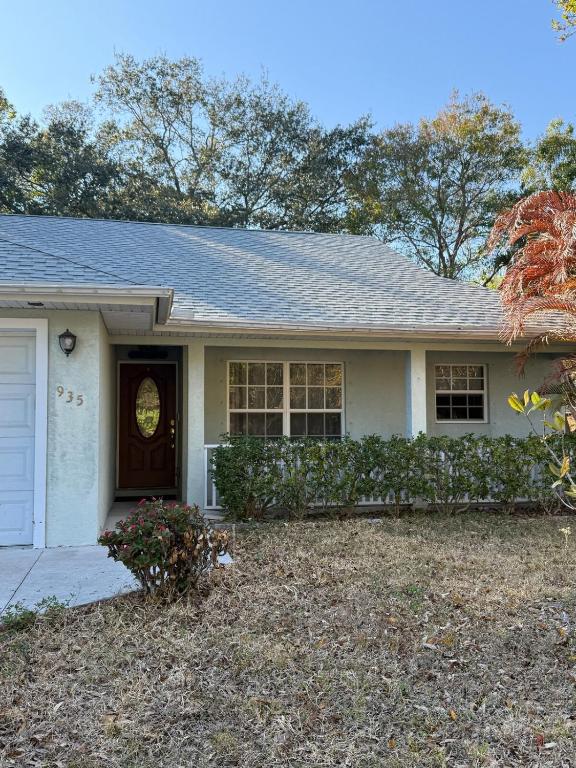 a white house with a brown door at Seras Home At Vero Beach in Vero Beach