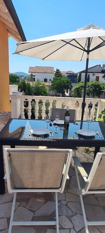 a table with an umbrella and two chairs at Villa Nikki in Bilice