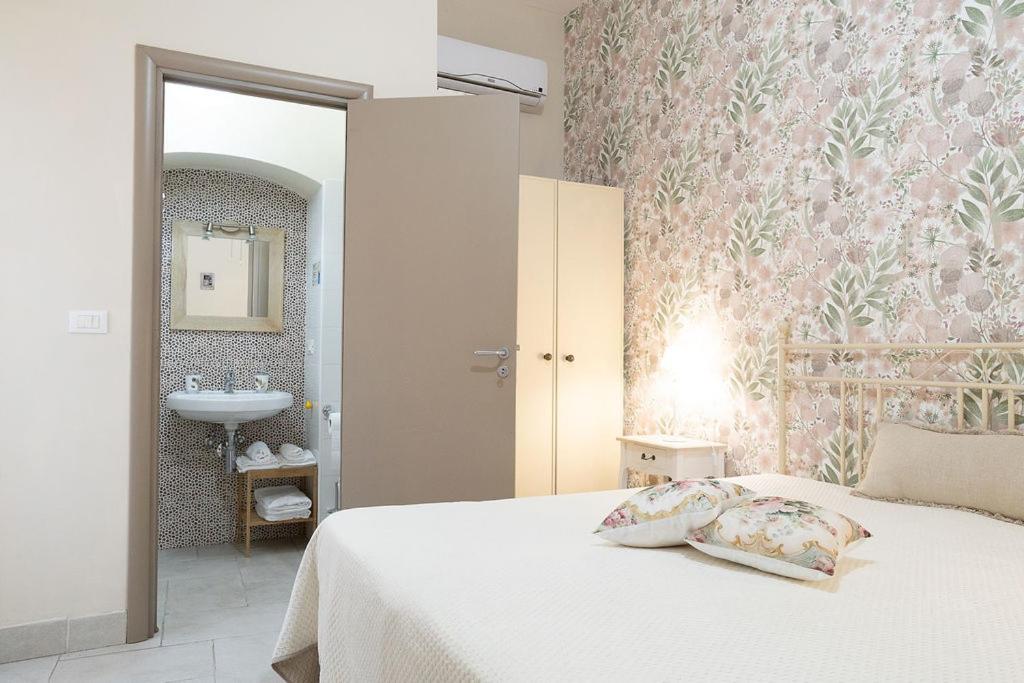 a bedroom with a white bed and a sink at Dimora dei Grifi in Ascoli Satriano