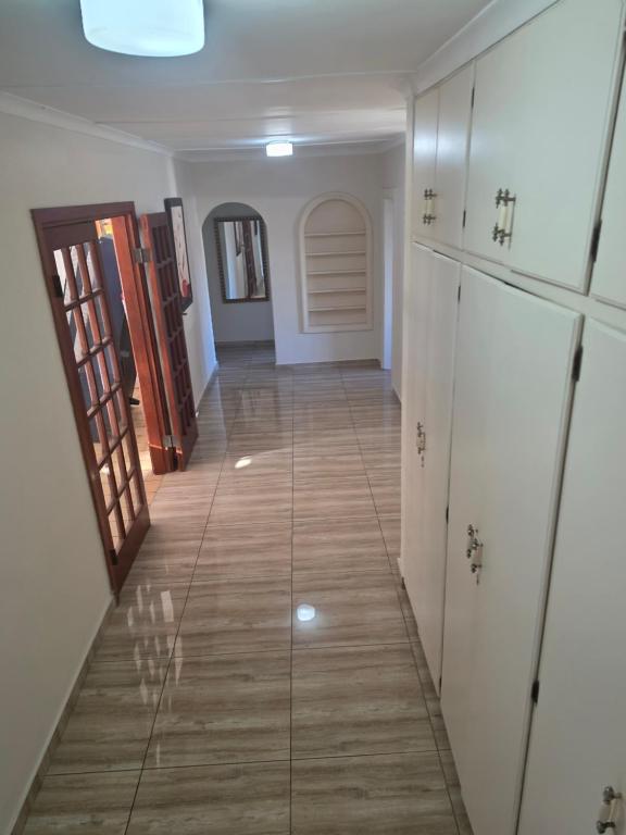 a hallway in a house with white walls and wooden floors at Southernstar 10 st Davids road in Arcadia