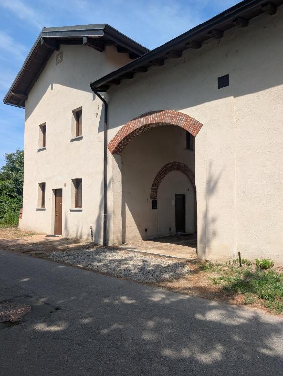 a large white building with an archway next to a street at Monterosa Apartment in Morghengo