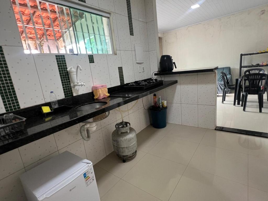 a kitchen with a sink and a stove in it at Hostel Coimbra Araçagi in Macajatuba