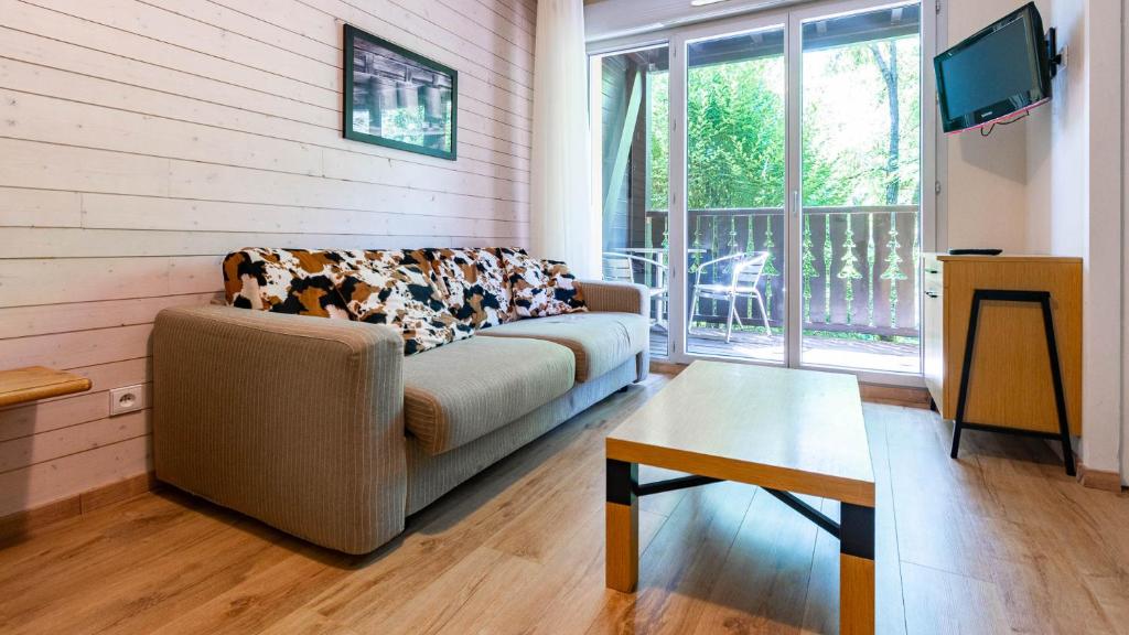 a living room with a couch and a table at Les Chalets d Ax N120 2P6 in Ax-les-Thermes