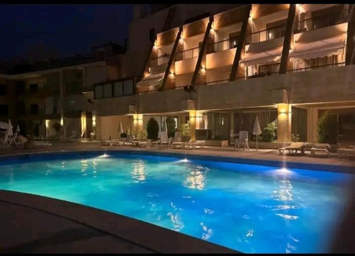 a large swimming pool in front of a building at night at chalet in Saint remon in Al ‘Ayn