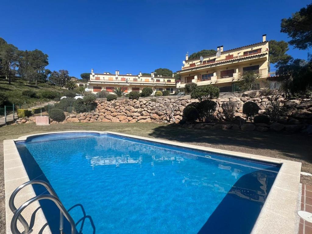 a large blue swimming pool in front of a building at La dorada 8 in Torroella de Montgrí