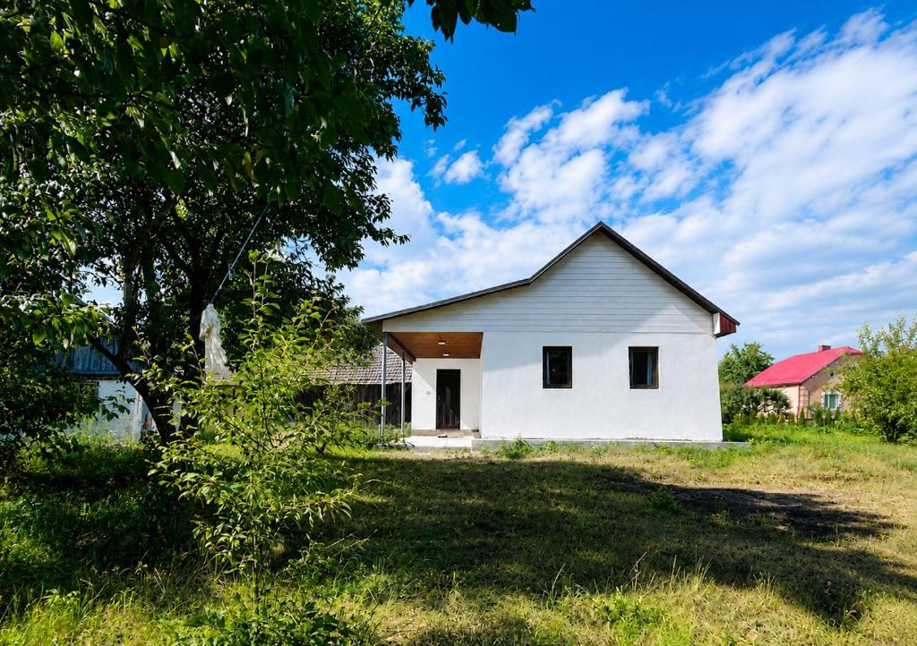 a white house in the middle of a field at У Катерини in Dvozhets