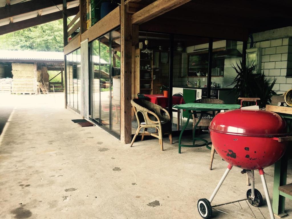 ein roter Grill mitten auf einer Terrasse in der Unterkunft Tiny farm studio in Maggia