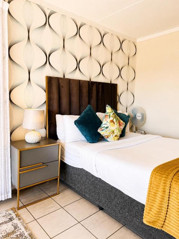 a bedroom with a large bed with a wooden headboard at MANDITAZ STUDIO in Fourways