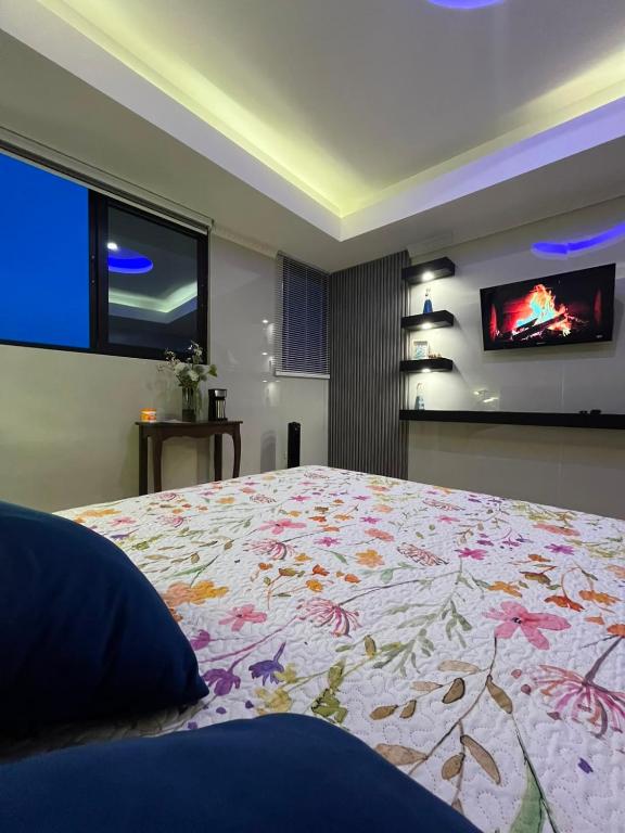 a bedroom with a bed and a tv on the wall at Height 909 Hostal in Juayúa