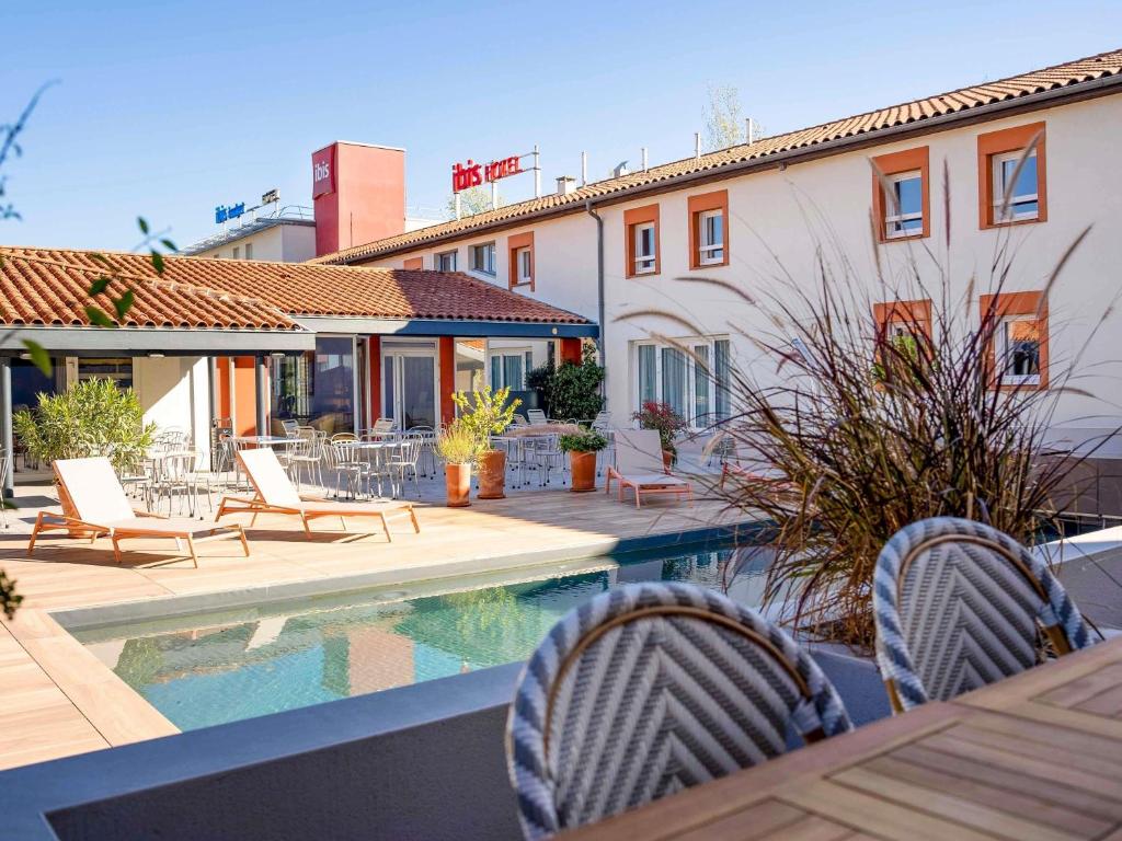 a patio with chairs and a pool and a house at ibis Montauban in Montauban