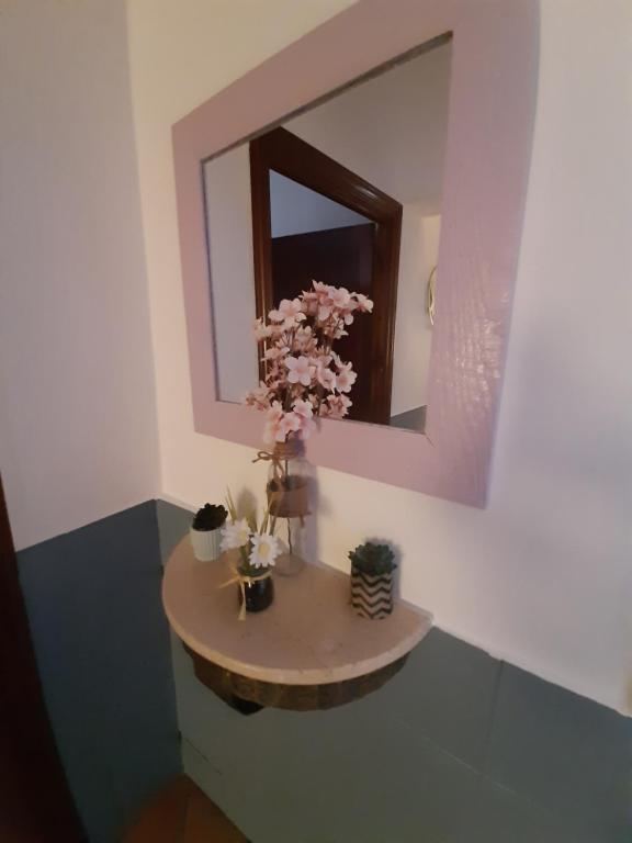 a small table with a mirror and flowers on it at Mallona in Pedro Rodríguez