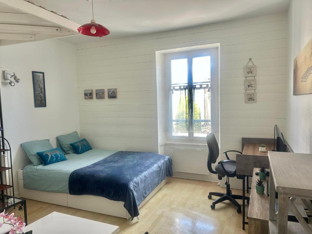 a bedroom with a bed and a desk and a window at Studio -Center - Lorient in Lorient