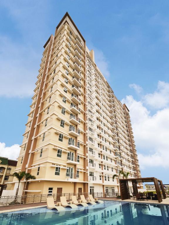 a large building with chairs and a swimming pool at Siena Tower - Gian's Nook in Manila
