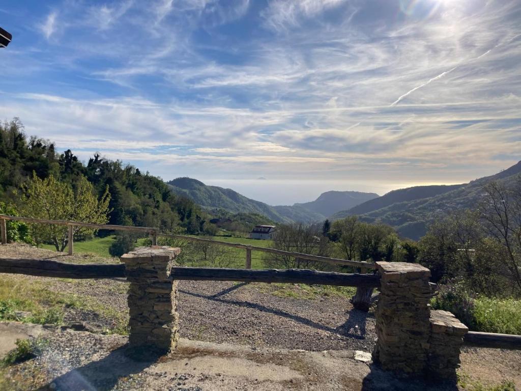 a stone fence with mountains in the background at Tenuta Mazzotti in Lago