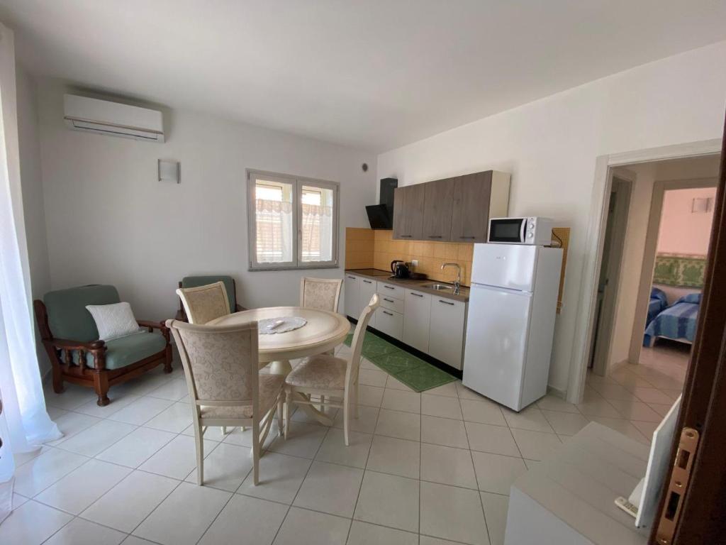 a kitchen with a table and a white refrigerator at Asfodelo in Galtellì