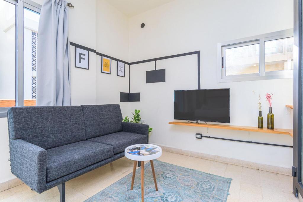 a living room with a couch and a tv at Factory Studio in Mar Mikhael in Al Mudawwar