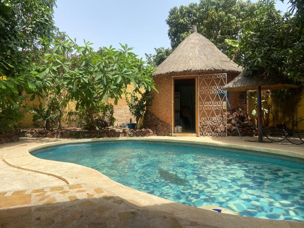 a swimming pool with a gazebo next to a house at Villa Les Flamboyants in Somone