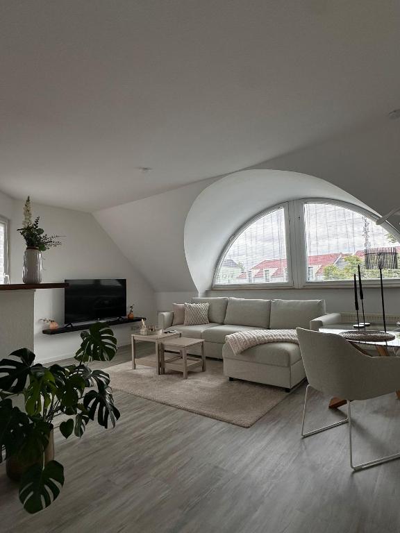 a living room with a couch and a large window at Schönblick Apartments in Schönebeck