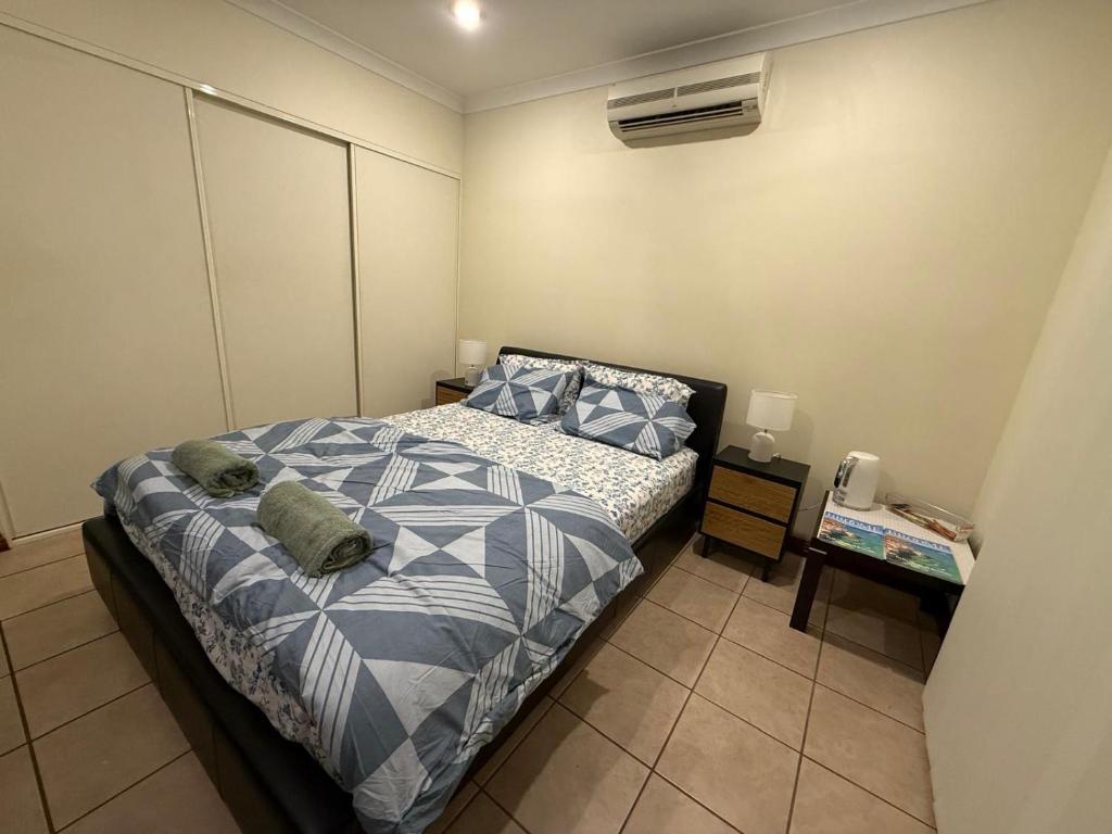 a bedroom with a bed with blue and white sheets at Broome Rest House in Broome