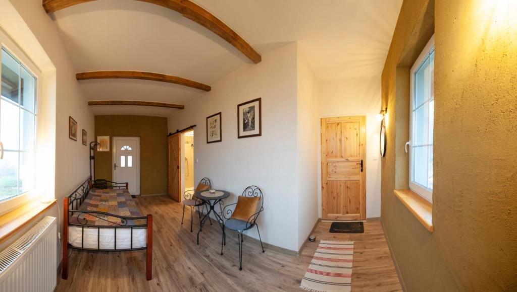 ein Zimmer mit einem Flur, auf dem ein Tisch und Stühle stehen in der Unterkunft Folwark Miodobytek in Łomnica