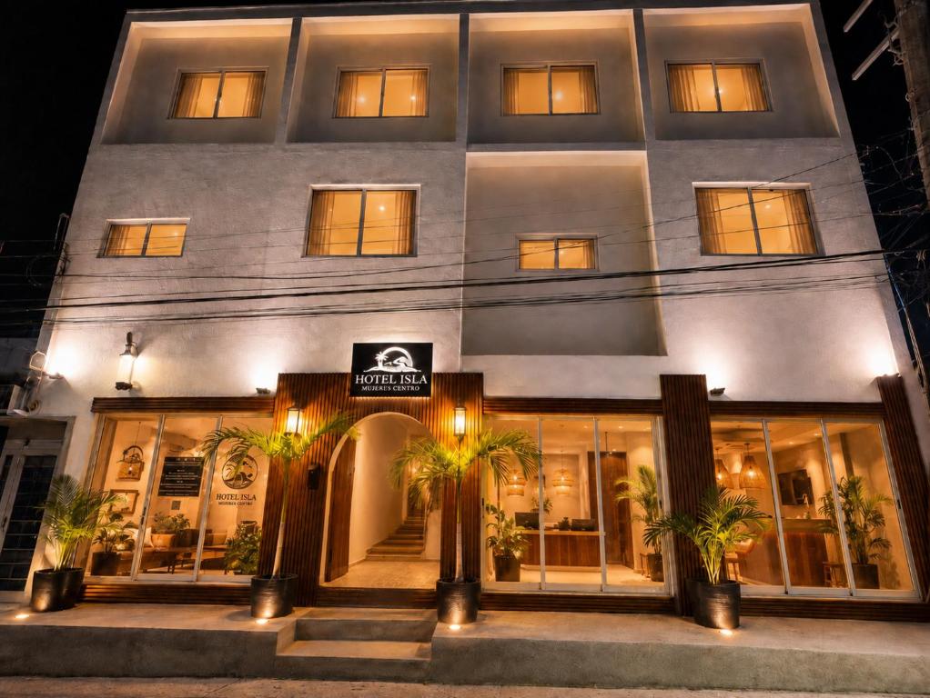 a white building with palm trees in front of it at Hotel Isla Mujeres Centro & Beach Club Included in Isla Mujeres