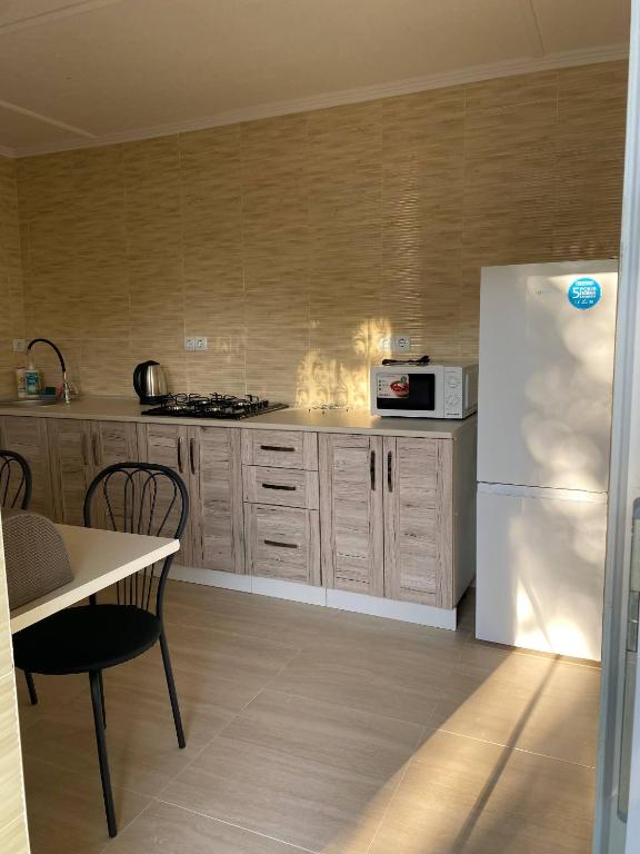 eine Küche mit einem weißen Kühlschrank und einem Tisch in der Unterkunft Язмін in Berehowe