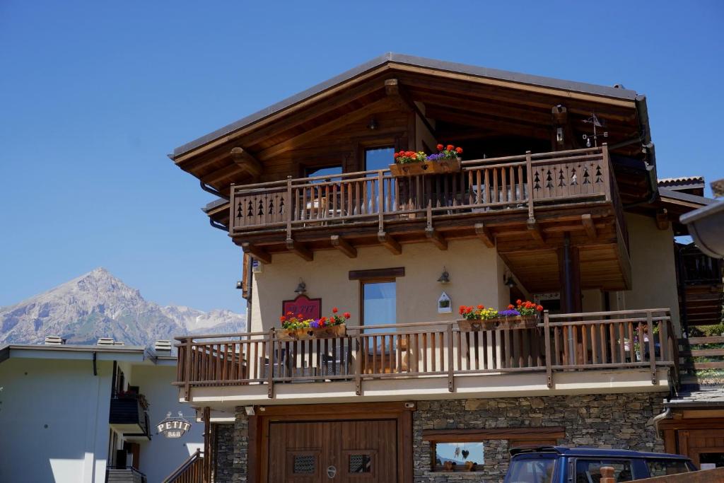 a house with balconies and flowers on it at B&B Petit in Sauze dʼOulx
