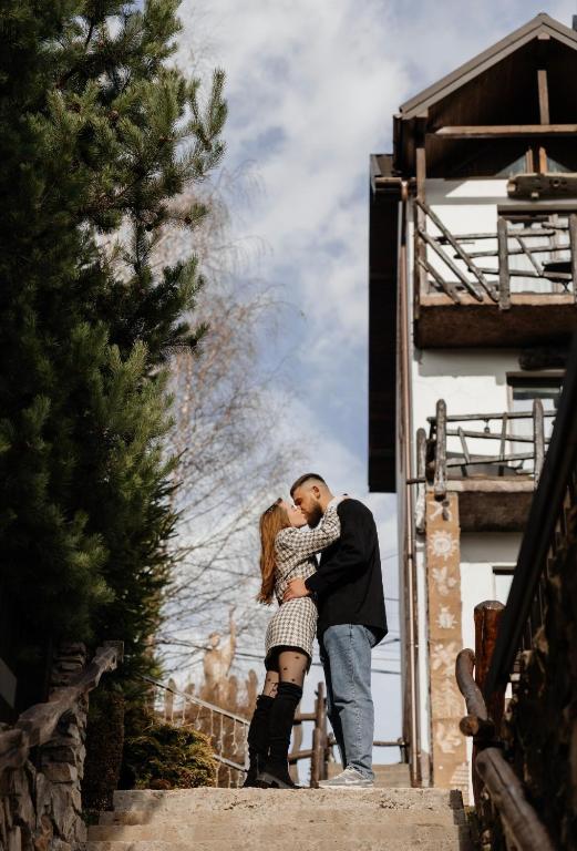 a man and woman kissing on the stairs of a house at Stara Pravda Hotel - History in Bukovel