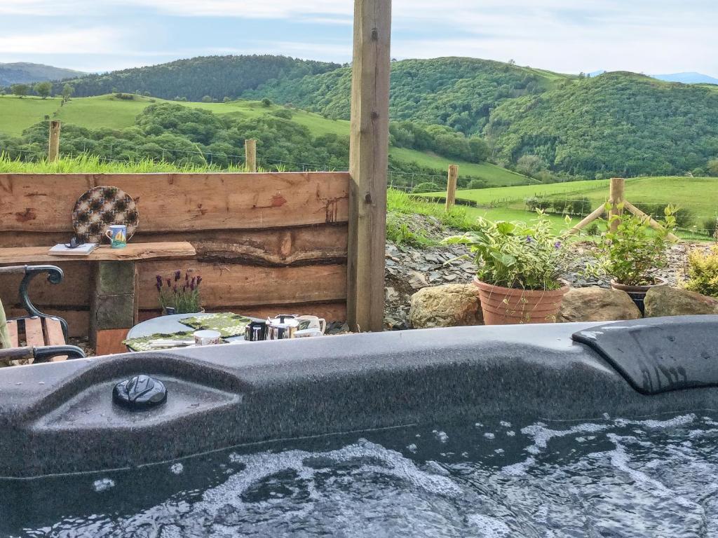 a bath tub in a yard with a view of mountains at Cowlas in Aberhosan