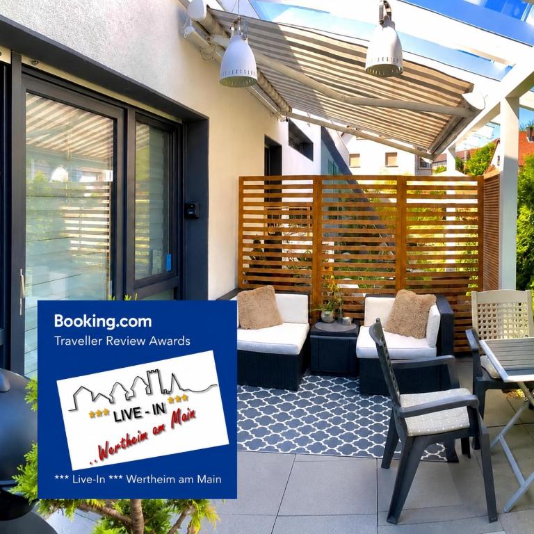 a patio with furniture and a sign that reads live in vancouver am wish at Tiny Apartment LIVE-IN Wertheim am Main in Wertheim