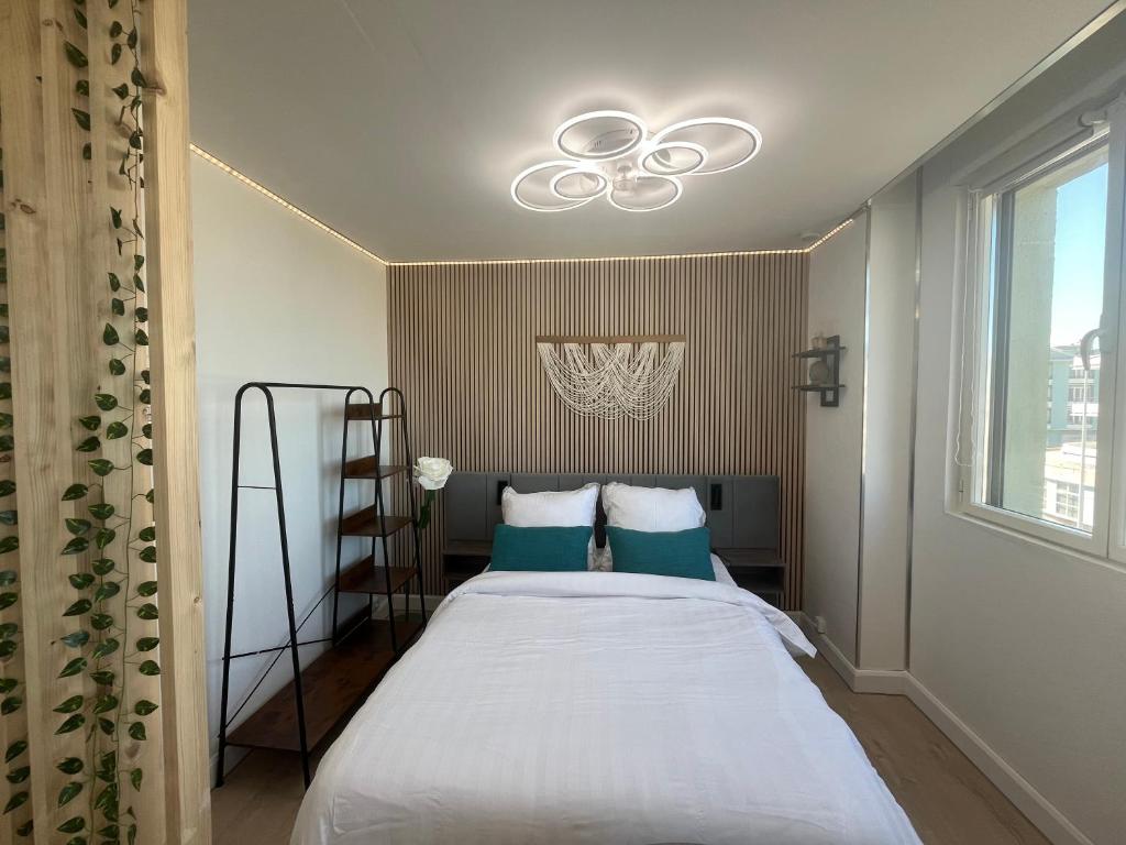 a bedroom with a bed with a ceiling fan at Studio Aloe horizon in Dunkerque