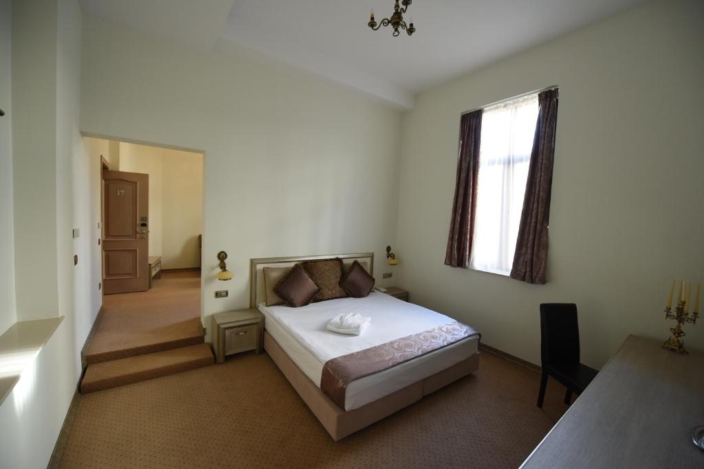 1 dormitorio con cama y ventana en Euro Hotel Grivita, en Bucarest