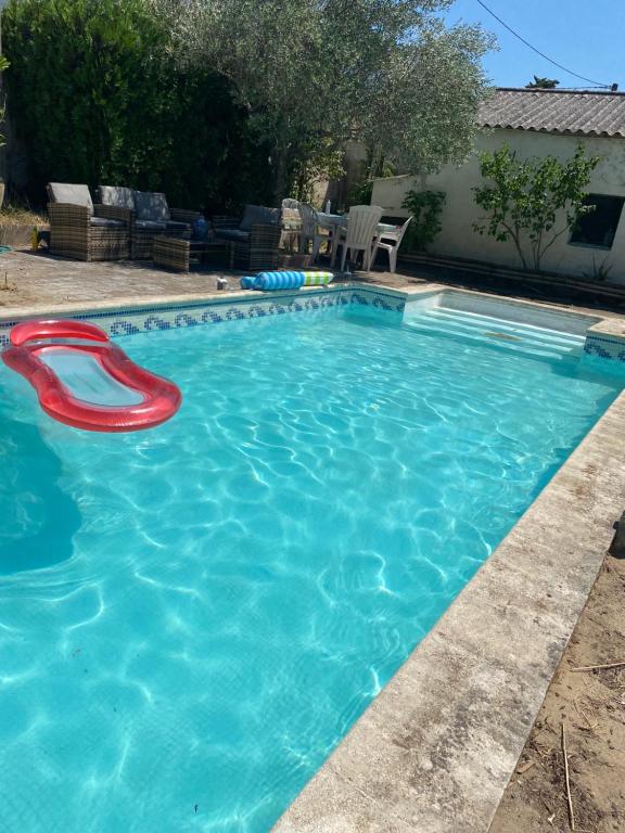 a swimming pool with a red frisbee in it at Villa Oasis Bollène in Bollène