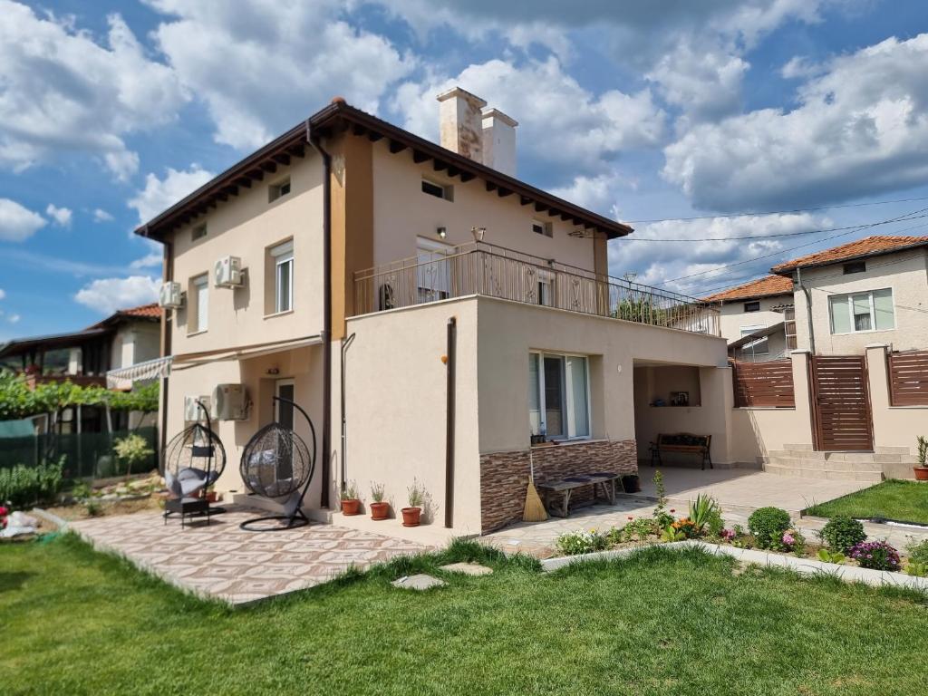 a house with a balcony and a yard at На Село in Garmen