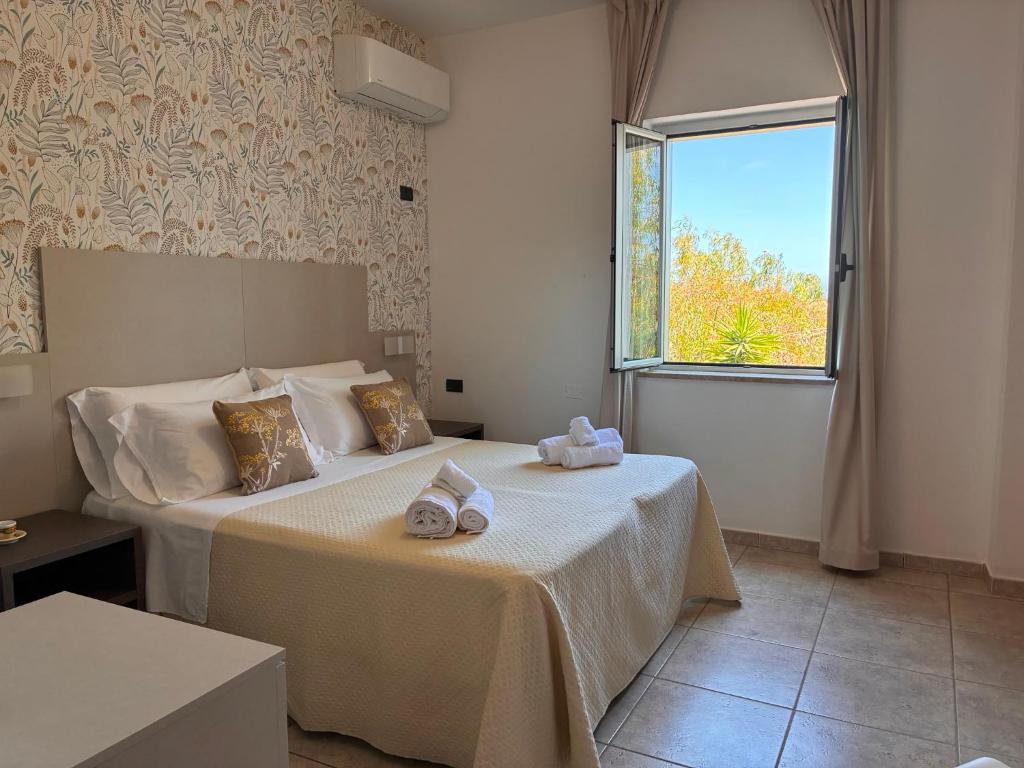a bedroom with a bed with towels on it at Hotel Paradiso 1972 in Schiavonea