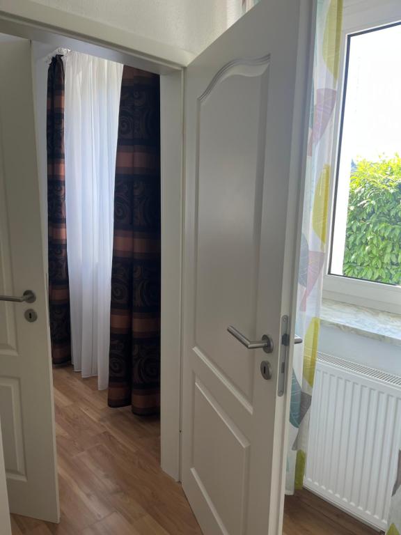 eine offene Tür in einem Zimmer mit Fenster in der Unterkunft Wilhelmsthal in Wilhelmsthal