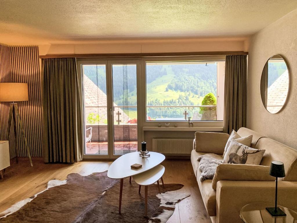 a living room with a couch and a table and a large window at Apartment Chäserruggblick by Interhome in Unterwasser