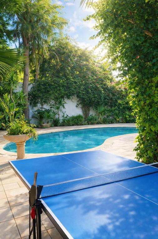 a ping pong table next to a swimming pool at Fantastic 6B Villa in Sidi Daoud