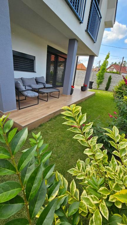 a patio with two couches and a grass yard at Vila Castrum in Nové Zámky