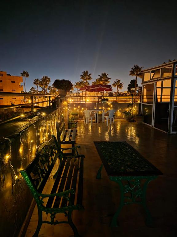 a patio with two benches and a table and lights at Morocco AG in Casablanca