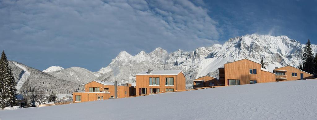 a group of buildings on top of a snow covered mountain at Rittis Alpin Chalets Dachstein in Ramsau am Dachstein