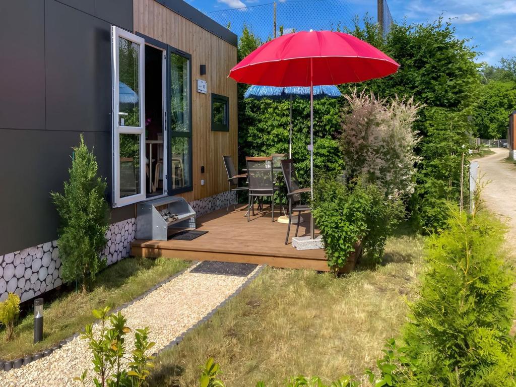 a patio with a red umbrella on a house at Holiday Home Tiny Haus Altmühlblick Nr- 83 by Interhome in Beilngries