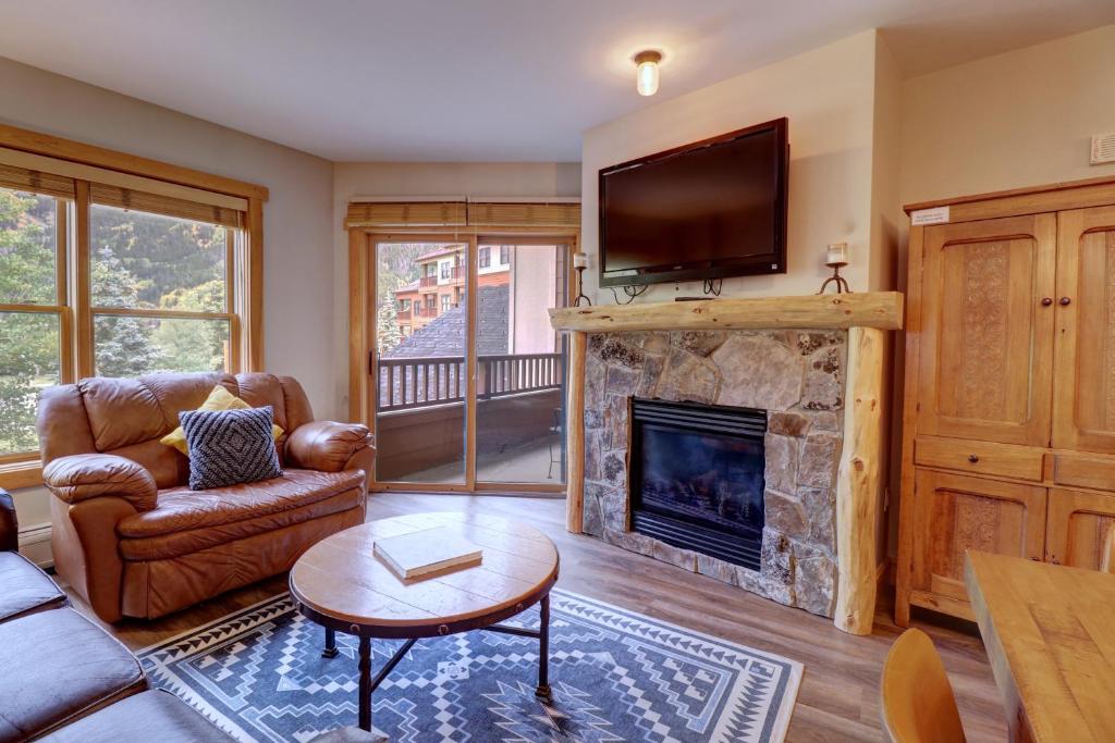 a living room with a fireplace and a tv at CS221 Copper Springs in Copper Mountain