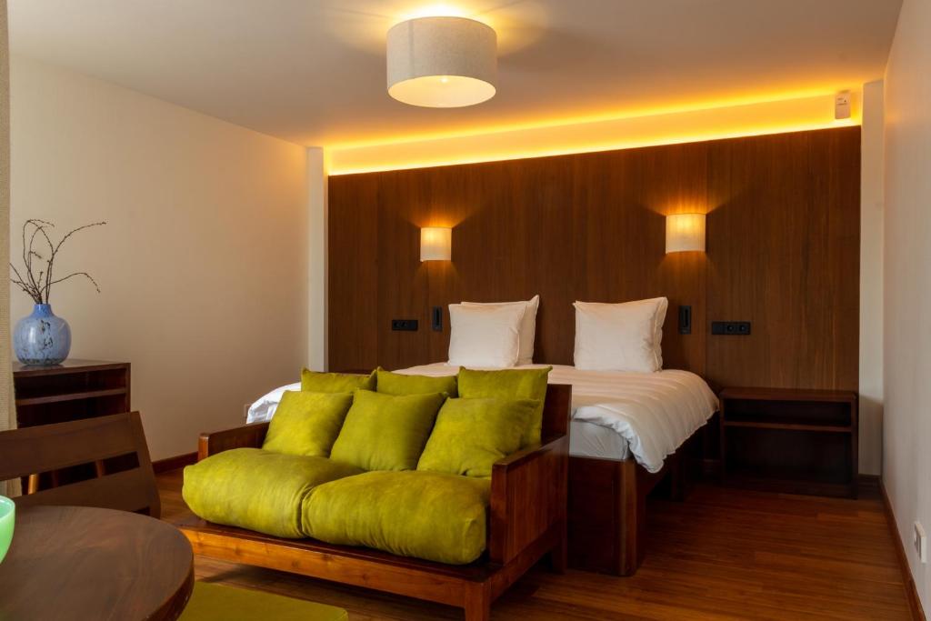 a bedroom with a bed with a green couch at Hotel The Exchange in Amsterdam